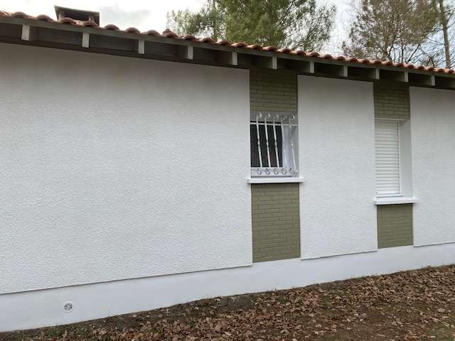 Détail d'un plafond parfaitement lisse sans traces de rouleau grâce à la technique de pulvérisation Airless.